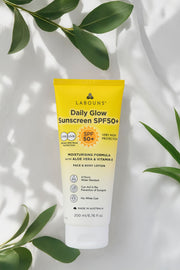 Labouns Daily Glow Sunscreen SPF50+ on a light background with green leaves.