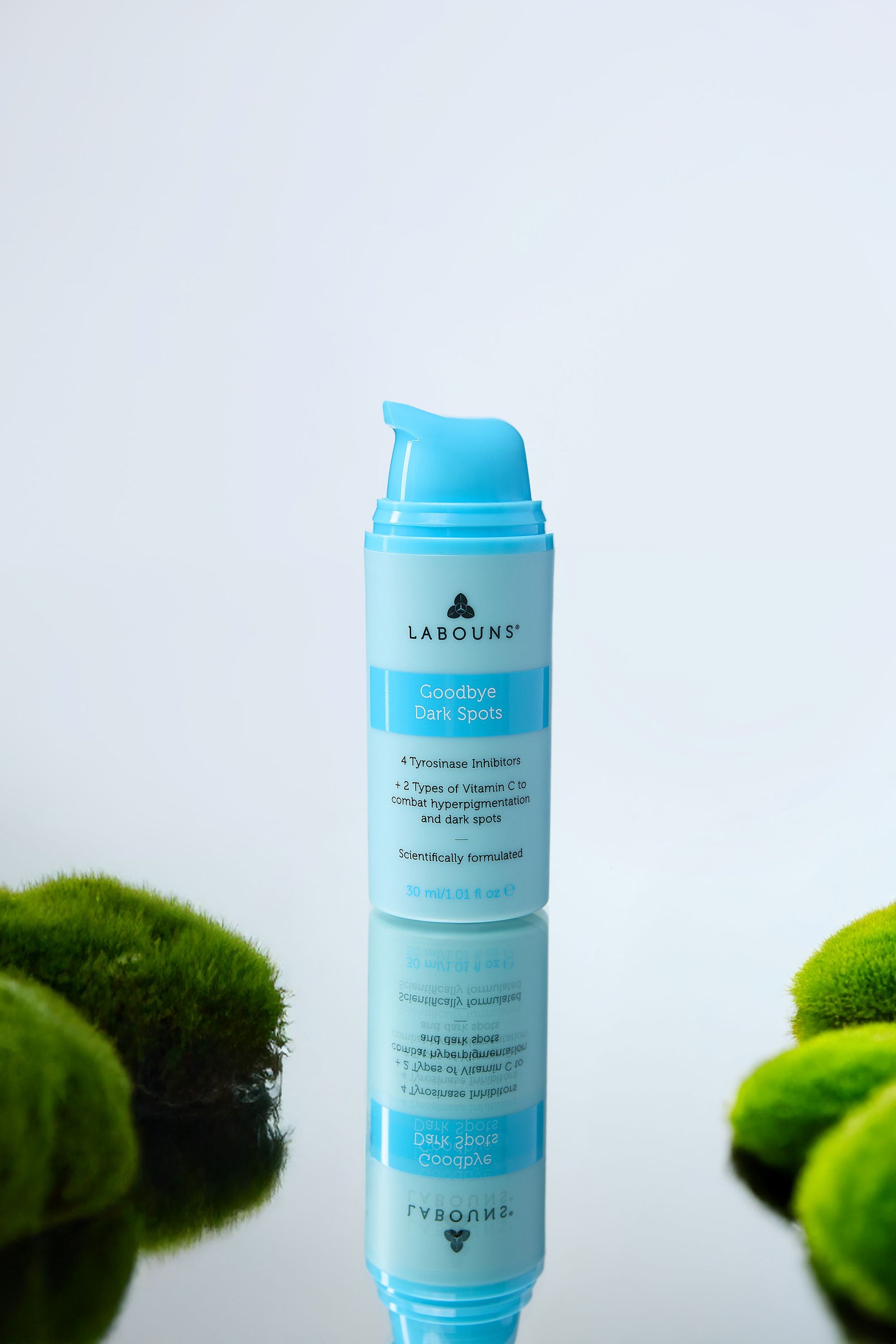 Blue skincare product with green plants on a light background